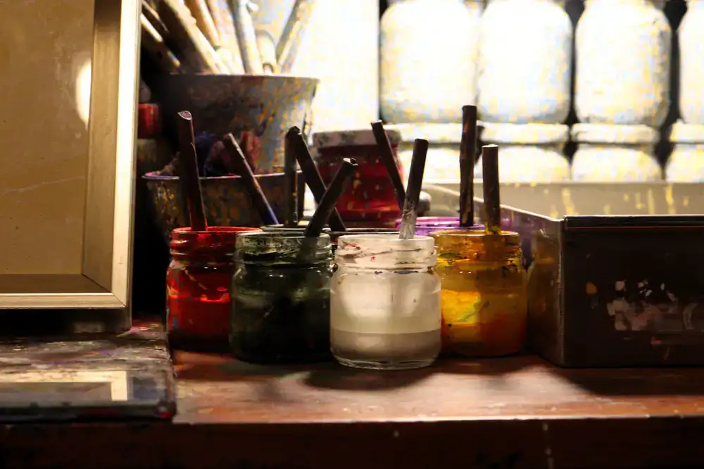 Traditional signwriting studio workbench with paints and brushes